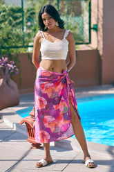Turn heads in this floral pink sarong wrap skirt and off-white crop top – the perfect beach vacation outfit for curvy women. Explore resort chic attire, ideal for poolside lounging or beach club outings. Sizes S–7XL available at NovelaFashion.